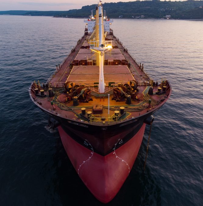 Large general cargo ship tanker bulk carrier, aerial top view at night.